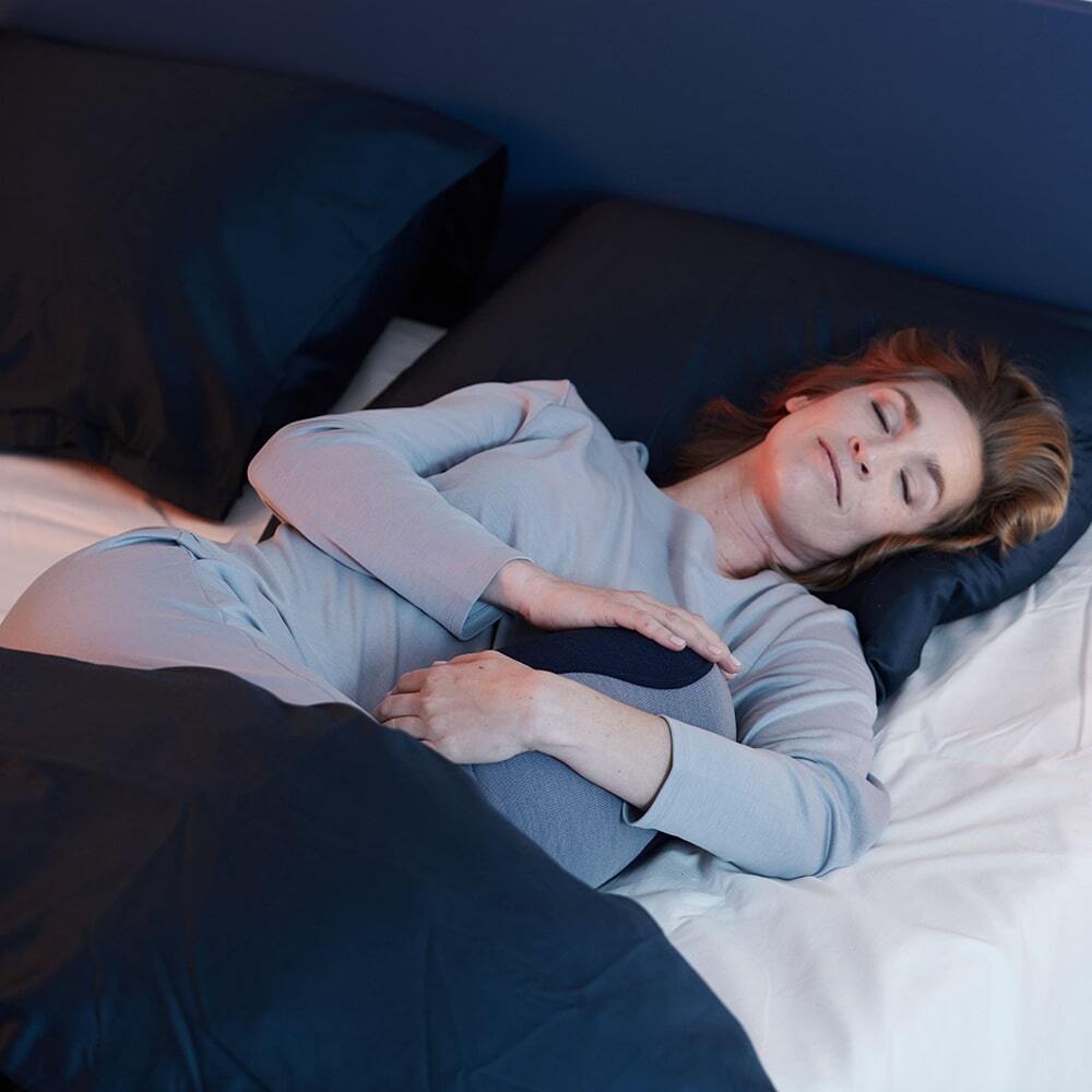 Woman in bed sleeping with the Somnox 2
