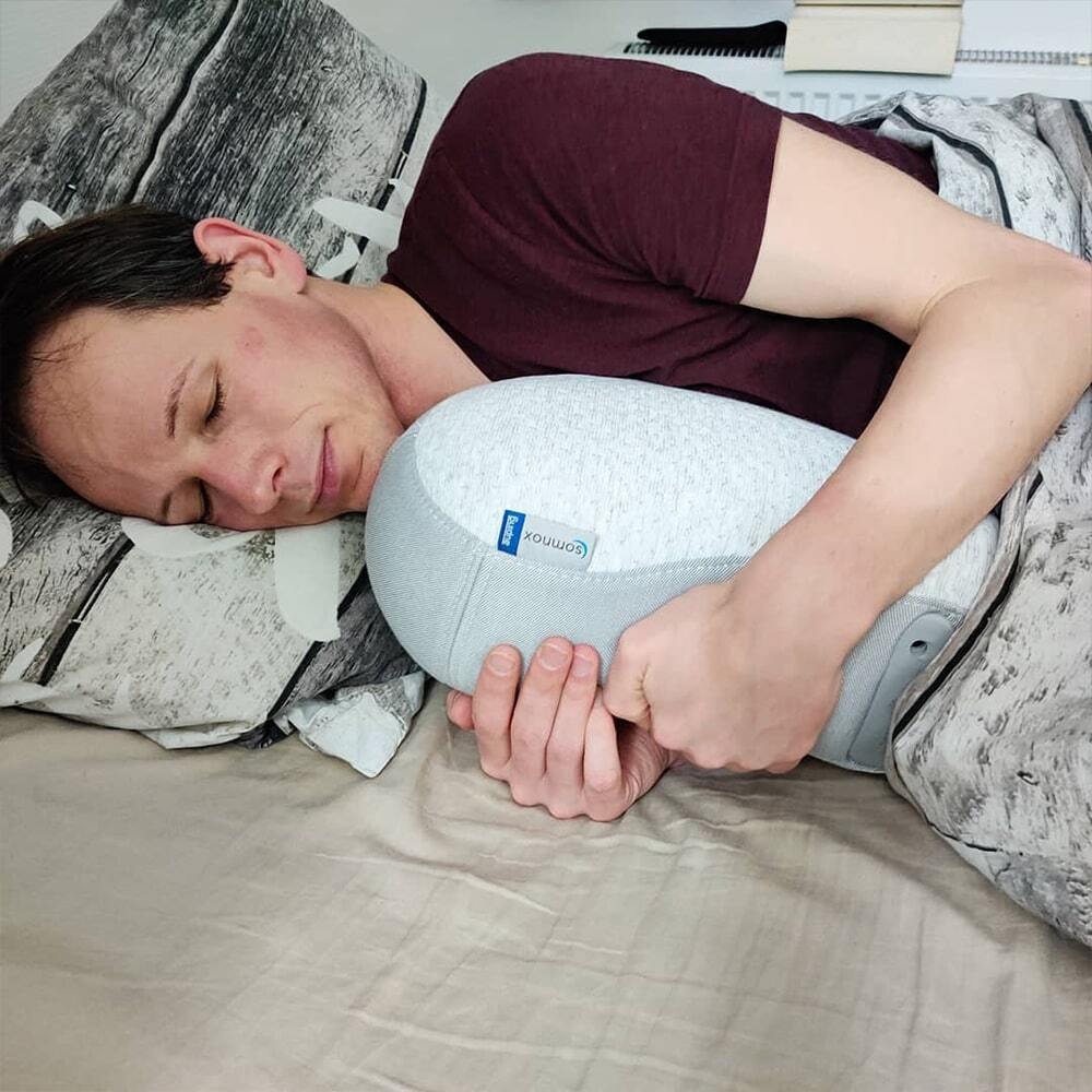 Man in bed sleeping with the Somnox Sleep Robot